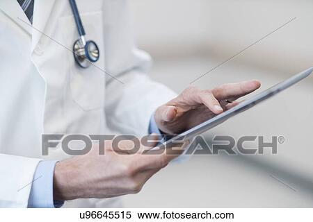 Stock Photography - Male doctor using digital tablet.. Fotosearch