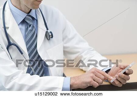 Male doctor using smartphone. View Large Photo Image Stock Image - Male doctor using smartphone.. Fotosearch