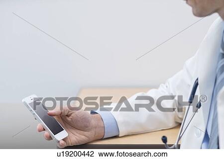 Male doctor using smartphone. View Large Photo Image Stock Image - Male doctor using smartphone.. Fotosearch