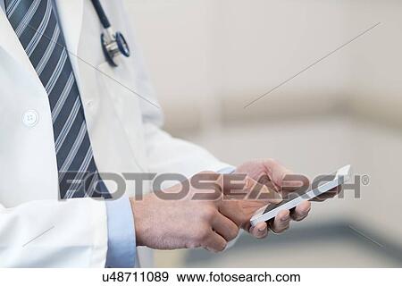 Male doctor using smartphone. View Large Photo Image Stock Photo - Male doctor using smartphone.. Fotosearch