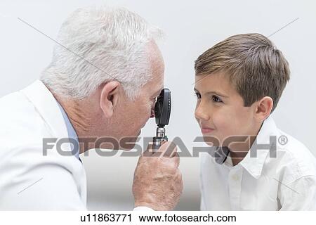 Male optician testing boy's eyesight. View Large Photo Image Stock Image - Male optician testing boy's eyesight.. Fotosearch