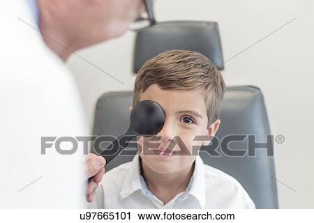 Male optician testing boy's eyesight. View Large Photo Image Stock Image - Male optician testing boy's eyesight.. Fotosearch