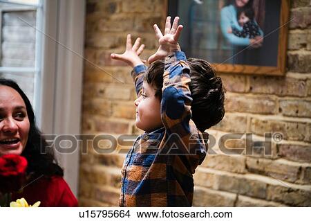 Male toddler with hands raised looking at mother, celebrating mothers day View Large Photo Image Picture - Male toddler with hands raised looking at mother, celebrating mothers day. Fotosearch
