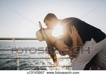 Man dipping and kissing woman on pier View Large Photo Image Stock Photo - Man dipping and kissing woman on pier. Fotosearch