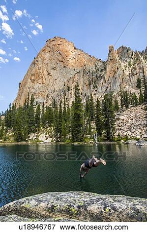 Stock Photo - Man diving into lake by mountain in Stanley, Idaho, USA. Fotosearch