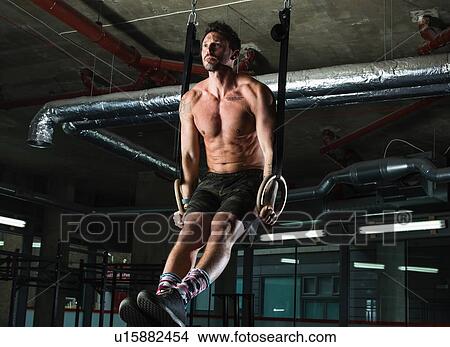 Man exercising with gymnastic rings in gym View Large Photo Image Picture - Man exercising with gymnastic rings in gym. Fotosearch