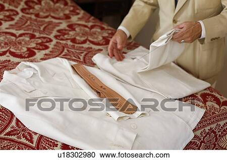 Man folding vintage white suit View Large Photo Image Stock Image - Man folding vintage white suit. Fotosearch