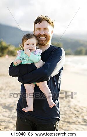 Man holding baby daughter on beach View Large Photo Image Stock Photography - Man holding baby daughter on beach. Fotosearch