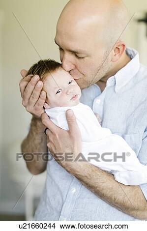 Picture - Man kissing his baby son. Fotosearch