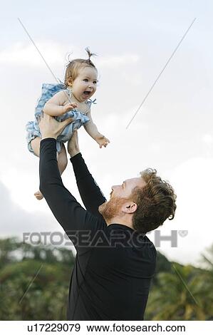 Man lifting baby daughter View Large Photo Image Stock Photo - Man lifting baby daughter. Fotosearch