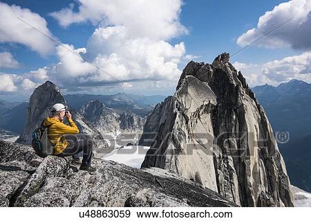Stock Photo - Man photographing mountain in Bugaboo Provincial Park, British Columbia, Canada. Fotosearch