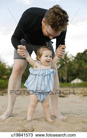 Man playing with baby daughter on beach View Large Photo Image Stock Image - Man playing with baby daughter on beach. Fotosearch