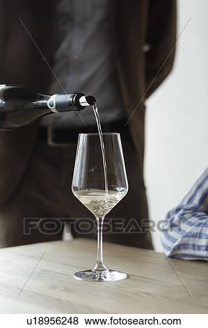 Stock Photo - Man pouring bottle of wine. Fotosearch