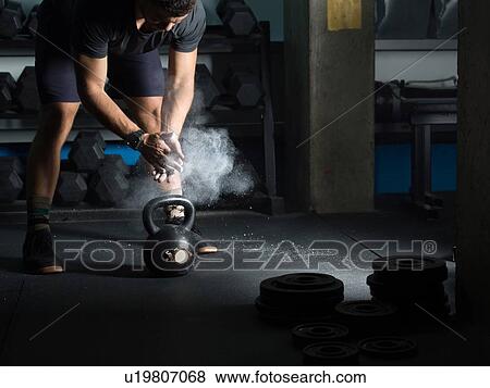 Man powdering hands before lifting kettlebell in gym View Large Photo Image Stock Photo - Man powdering hands before lifting kettlebell in gym. Fotosearch