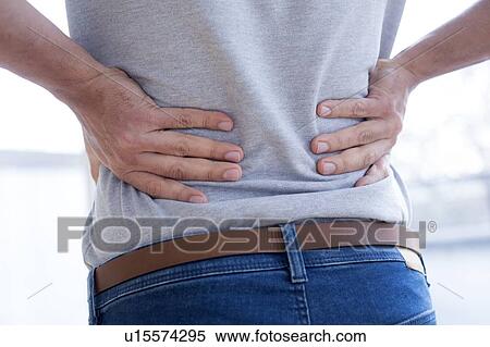 Stock Photography - Man touching his back in pain.. Fotosearch