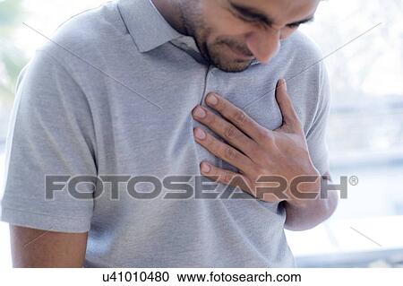 Stock Image - Man touching his chest in pain.. Fotosearch