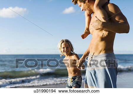 Man walking with his children on beach View Large Photo Image Picture - Man walking with his children on beach. Fotosearch