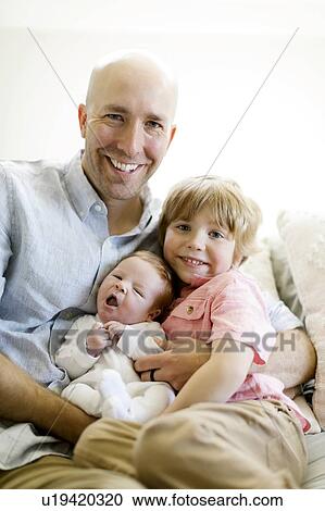 Man with his sons on sofa View Large Photo Image Stock Image - Man with his sons on sofa. Fotosearch