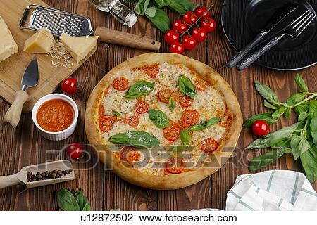 Stock Image - Margherita pizza with ingredients. Fotosearch