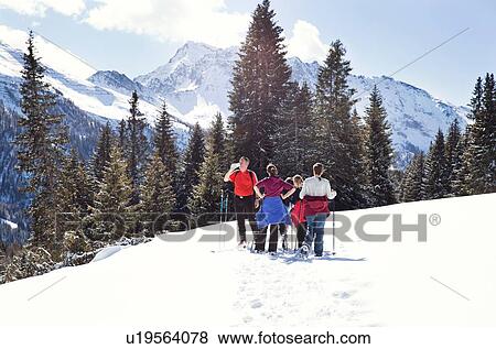 Mature couple and daughters taking a break while snowshoeing in snow covered mountain landscape, Styria, Tyrol, Austria View Large Photo Image Stock Photo - Mature couple and daughters taking a break while snowshoeing in snow covered mountain landscape, Styria, Tyrol, Austria. Fotosearch