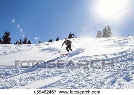 Mature man skiing down sunlit snow covered mountain, Styria, Tyrol, Austria View Large Photo Image Stock Photo - Mature man skiing down sunlit snow covered mountain, Styria, Tyrol, Austria. Fotosearch
