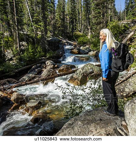 Mature woman standing by river through forest in Stanley, Idaho, USA View Large Photo Image Stock Image - Mature woman standing by river through forest in Stanley, Idaho, USA. Fotosearch