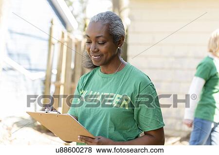 Stock Photo - Mature woman volunteer with clipboard. Fotosearch