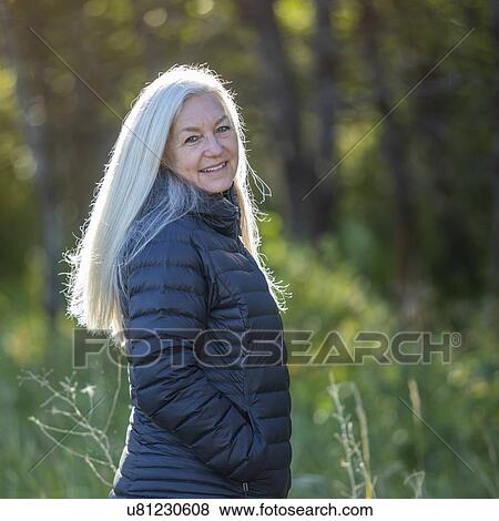 Mature woman wearing black jacket by forest View Large Photo Image Stock Photo - Mature woman wearing black jacket by forest. Fotosearch