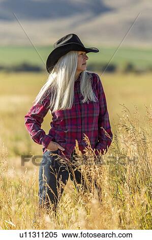 Mature woman wearing cowboy hat in field View Large Photo Image Stock Photography - Mature woman wearing cowboy hat in field. Fotosearch