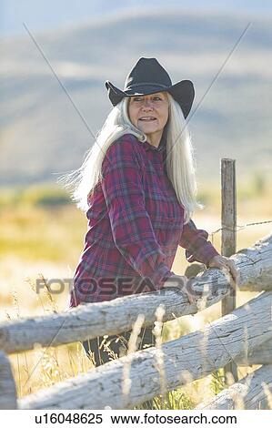 Mature woman wearing cowboy hat in field View Large Photo Image Stock Photography - Mature woman wearing cowboy hat in field. Fotosearch