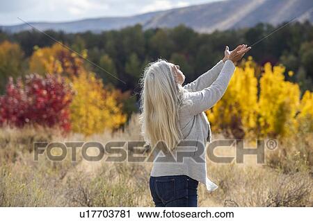 Mature woman with her arms raised by autumn forest View Large Photo Image Stock Image - Mature woman with her arms raised by autumn forest. Fotosearch