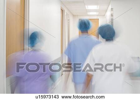 Stock Image - Medical staff walking down hospital corridor.. Fotosearch