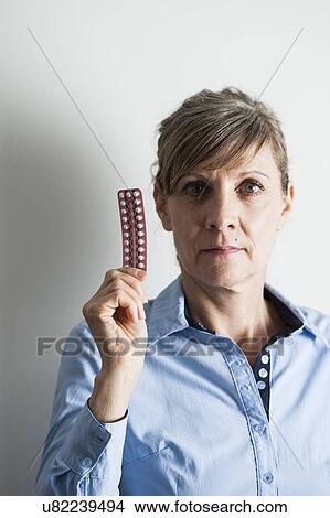 Menopausal woman with hormone replacement therapy (HRT) pills. HRT pills are synthetic hormones used to treat menopausal women. They counteract the hormone deficiency that occurs at menopause. View Large Photo Image Picture - Menopausal woman with hormone replacement therapy (HRT) pills. HRT pills are synthetic hormones used to treat menopausal women. They counteract the hormone deficiency that occurs at menopause.. Fotosearch