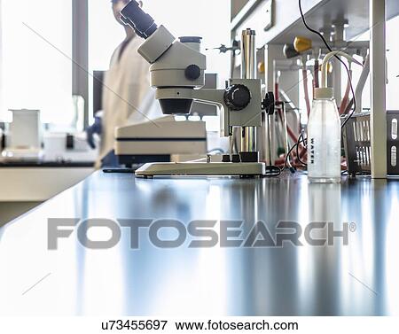 Stock Photo - Microscope on laboratory counter, surface level view. Fotosearch