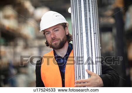 Mid adult male construction worker carrying building material on construction site, portrait View Large Photo Image Stock Image - Mid adult male construction worker carrying building material on construction site, portrait. Fotosearch