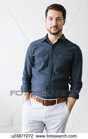 Mid adult man wearing blue button down shirt View Large Photo Image Stock Image - Mid adult man wearing blue button down shirt. Fotosearch