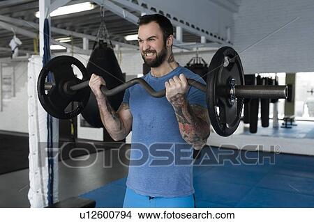 Mid adult man weight lifting in gym View Large Photo Image Picture - Mid adult man weight lifting in gym. Fotosearch