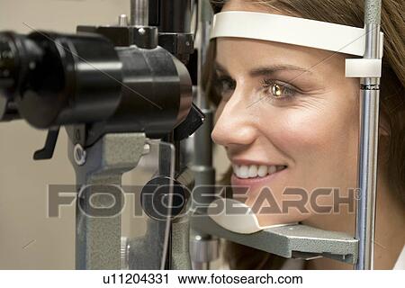 Stock Image - Mid adult woman having eye test.. Fotosearch