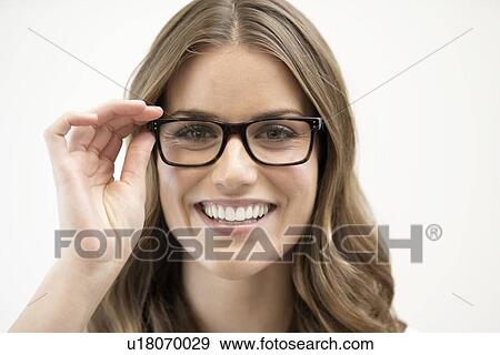Stock Photo - Mid adult woman wearing glasses, studio shot.. Fotosearch