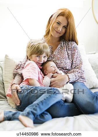 Stock Photograph - Mother and her sons on bed. Fotosearch