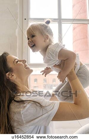 Mother lifting daughter View Large Photo Image Picture - Mother lifting daughter. Fotosearch