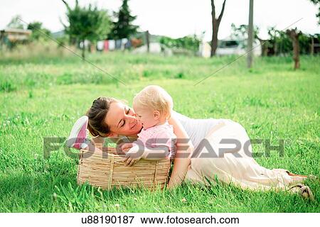 Mother lying on grass gazing at toddler daughter, Arezzo, Tuscany, Italy View Large Photo Image Stock Photo - Mother lying on grass gazing at toddler daughter, Arezzo, Tuscany, Italy. Fotosearch