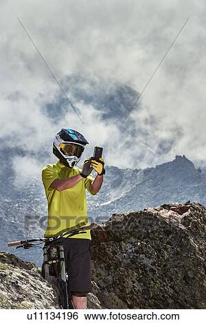 Mountain biker taking photo, Saas-Fee, Valais, Switzerland View Large Photo Image Stock Photograph - Mountain biker taking photo, Saas-Fee, Valais, Switzerland. Fotosearch
