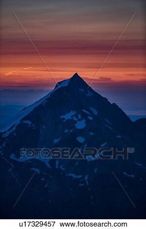 Mountain summit, orange glow on horizon in background, Saas-Fee, Valais, Switzerland View Large Photo Image Stock Photo - Mountain summit, orange glow on horizon in background, Saas-Fee, Valais, Switzerland. Fotosearch