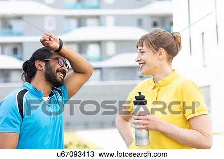 Stock Image - Multi-ethnic couple taking break after exercise. Fotosearch