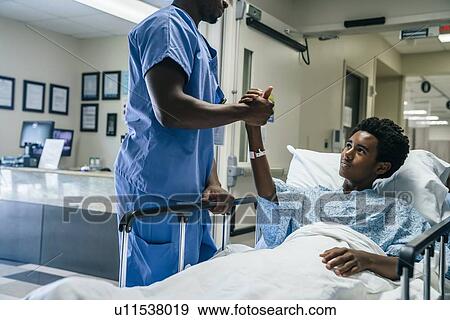 Nurse holding teenage patient's hand View Large Photo Image Stock Photo - Nurse holding teenage patient's hand. Fotosearch