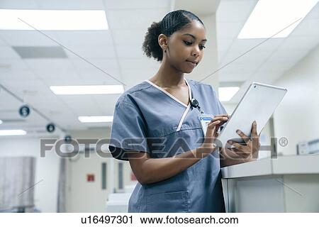 Stock Image - Nurse using digital tablet in hospital. Fotosearch