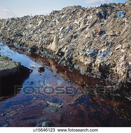 Stock Image - Oily hazardous waste in trench on landfill site.. Fotosearch