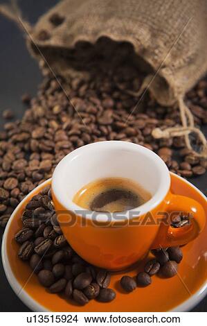 Orange cup of coffee with roasted coffee beans View Large Photo Image Picture - Orange cup of coffee with roasted coffee beans. Fotosearch