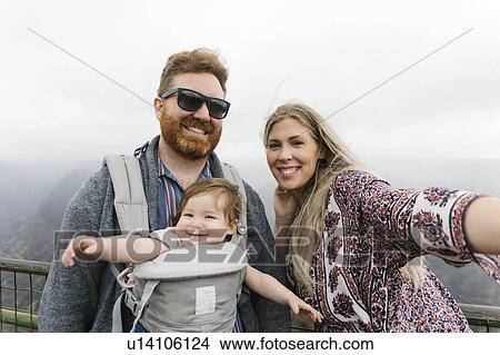 Parents with their baby girl in baby carrier View Large Photo Image Picture - Parents with their baby girl in baby carrier. Fotosearch